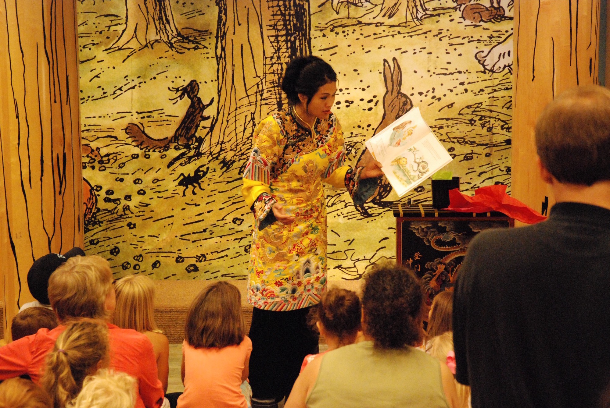 Grace Chang in an embroidered costume performing a book reading for children at Barnes and Noble