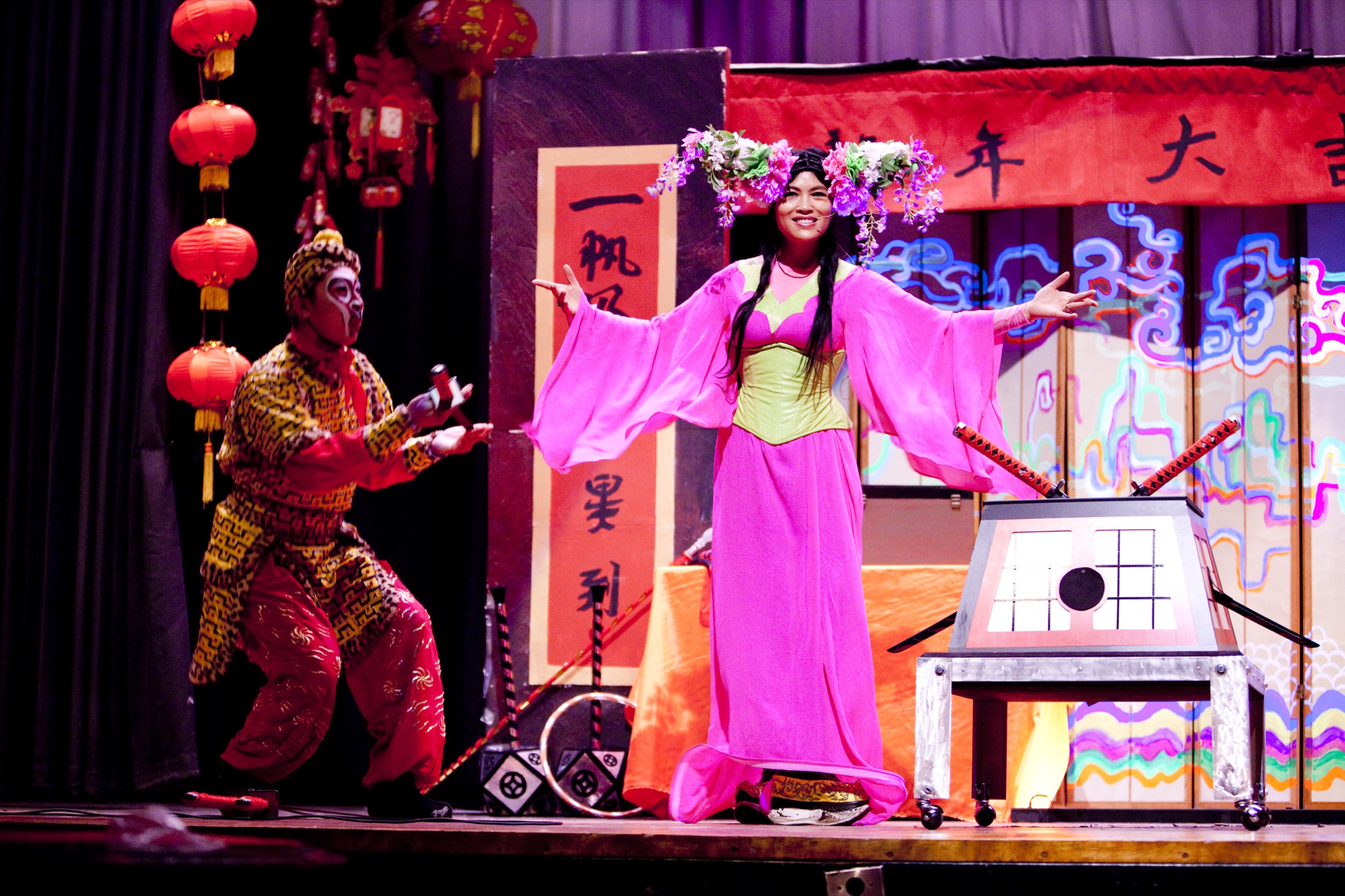 Grace Chang performing on stage in a pink and green costume with flower crown during a Chinese New Year show